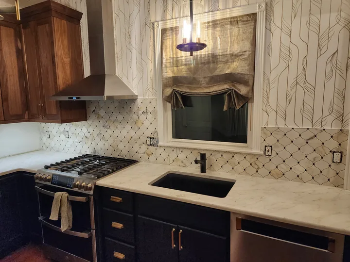 Kitchen with a light diamond-pattern mosaic backsplash, dark cabinets, a range, sink, and window